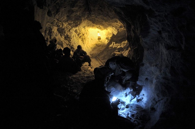 Ten miners in a mine inspect the rubbles left by an explosion they have set off