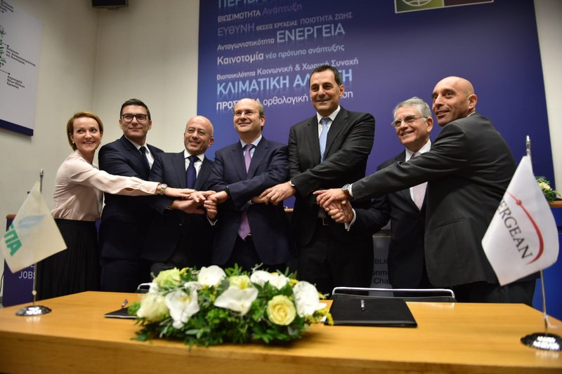 Energean and DEPA officials hold hands with the Greek Energy Minister