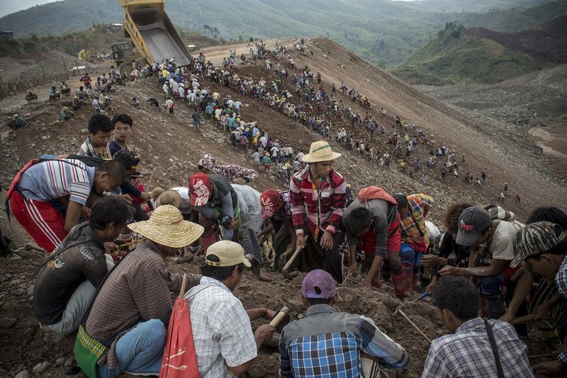 Small-scale miners search for stones as trucks from jade mining companies dump waste in Hpakant, Myanmar. Photo credit: Minzayar