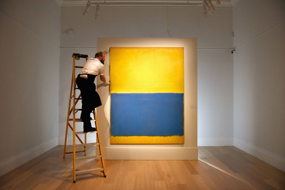 A gallery technician makes adjustments to the hanging of Mark Rothko's 'Untitled (Yellow and Blue), executed in 1954, as the work goes on show at Sotheby's on April 10, 2015 in London, England