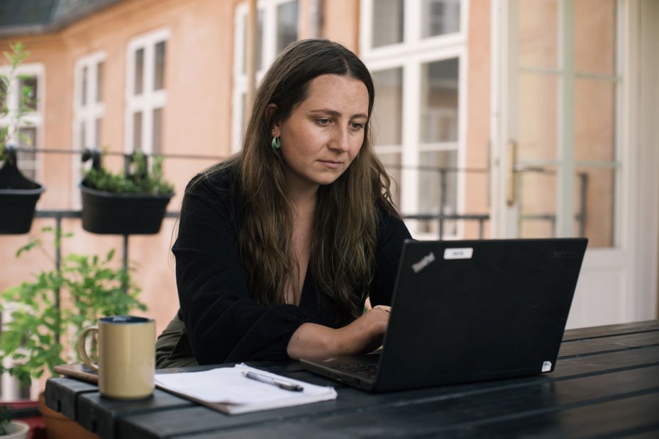 portrait of annika, a defender from denmark who has faced digital threats, on a computer