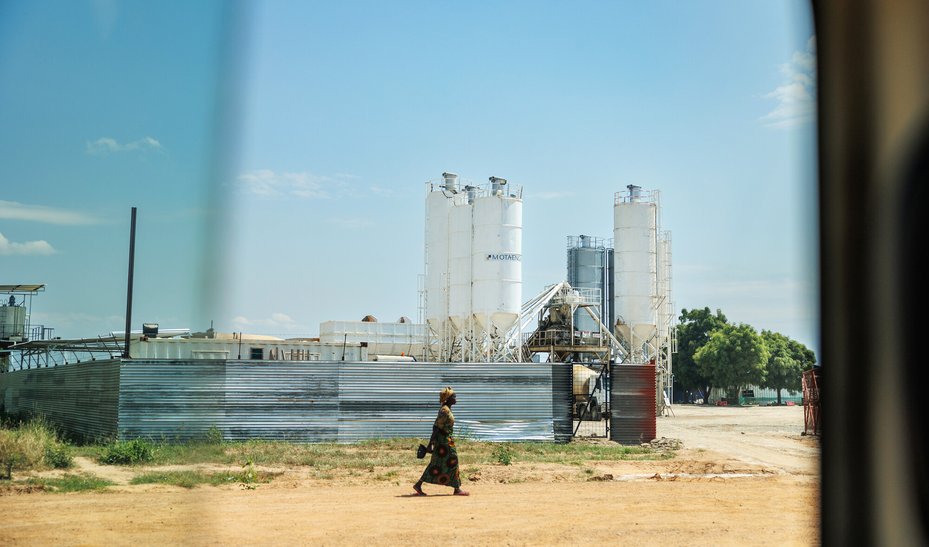A woman past an oil facility in Buliisa, Uganda