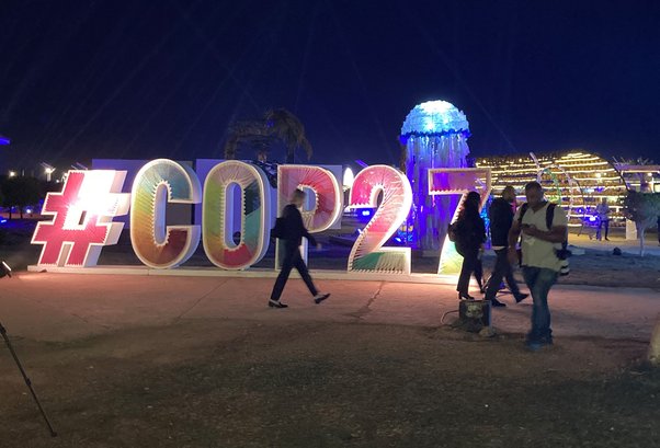 lit up cop27 sign in glasgow at night