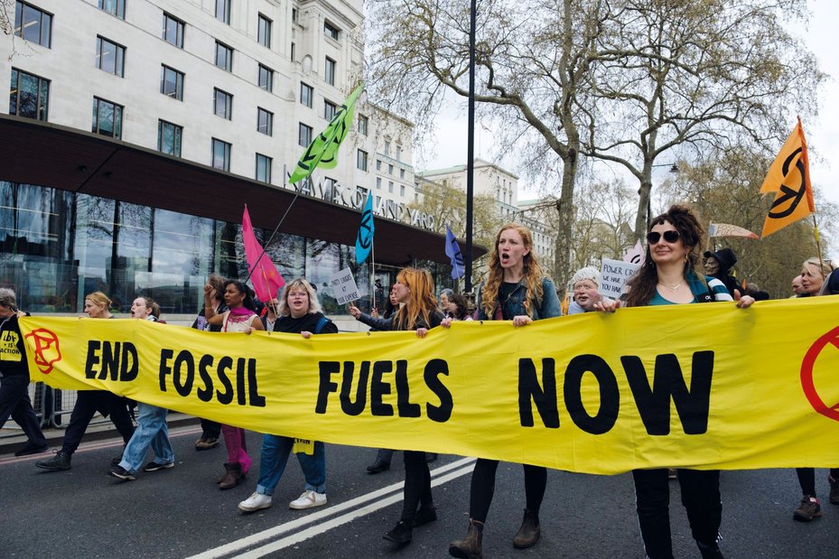 demonstrators march and hold banner at End Fossil Fuels Protest