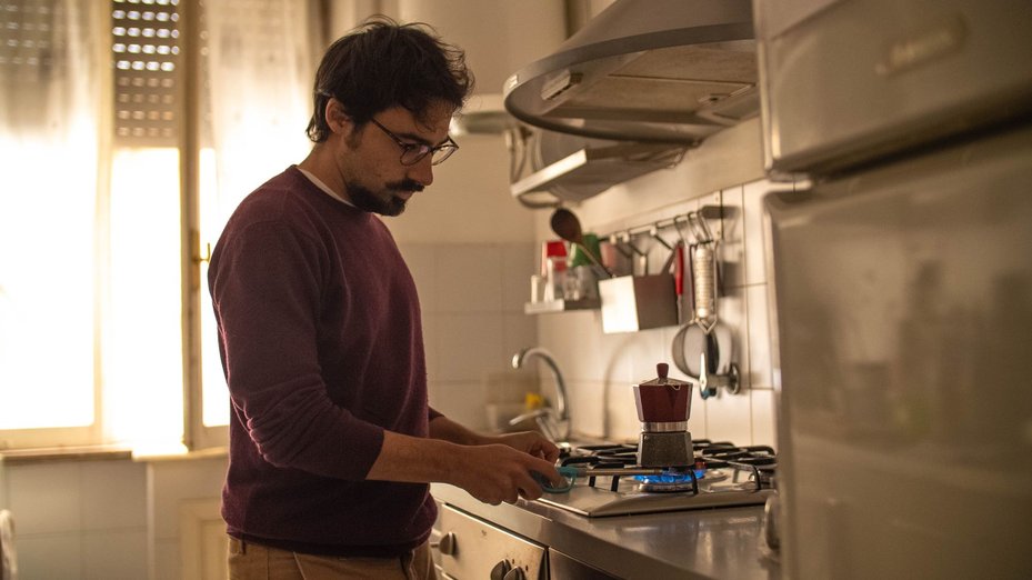 man heats kettle on gas stove, demonstration of energy crisis