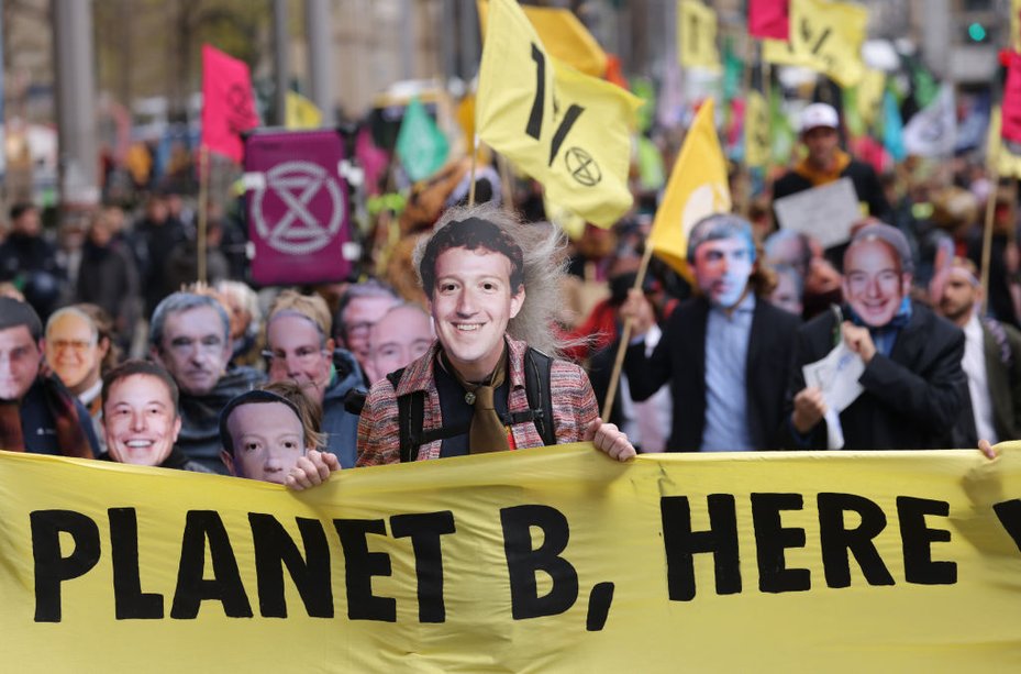 Activists from Extinction Rebellion march through Berlin dressed as billionaires, including Big Tech CEOs Elon Musk and Mark Zuckerberg