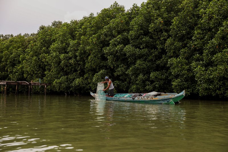 Fisherman in boat on river in Paombong Philippines