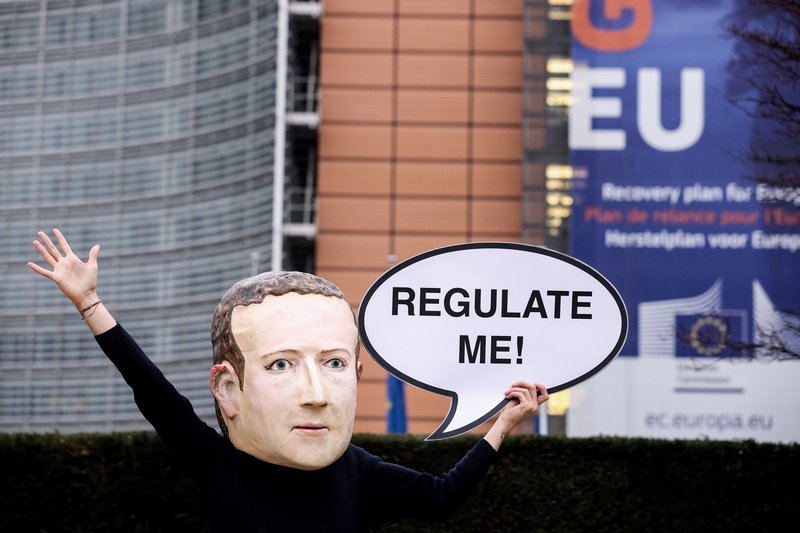 An activist of environmental NGO Avaaz wearing a mask depicting Facebook CEO Mark Zuckerberg