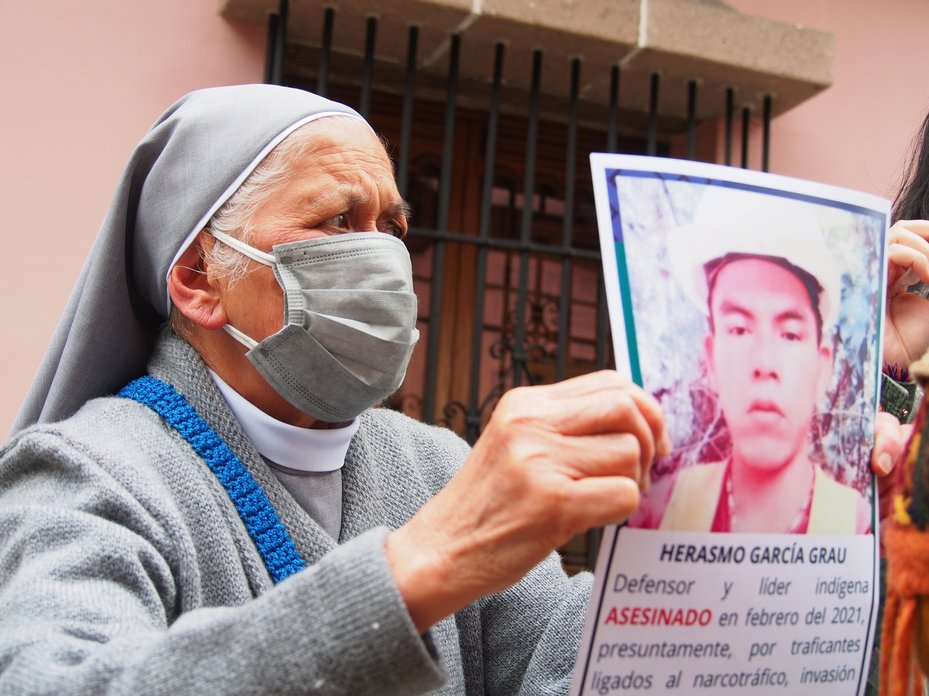 A nun holds a photo of Herasmo Garcia Grau, a murdered indigenous leader, Lima, Peru