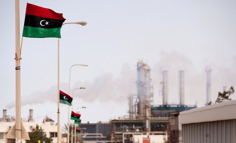 Libyan flag flutters outside an oil refinery in Zawiya