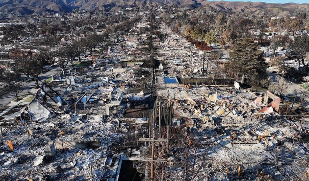 An aerial photograph of blackened buildings and scorched trees following the aftermath of the LA fires in January 2025.