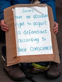 A close up photo of someone holding a handmade sign that reads: 