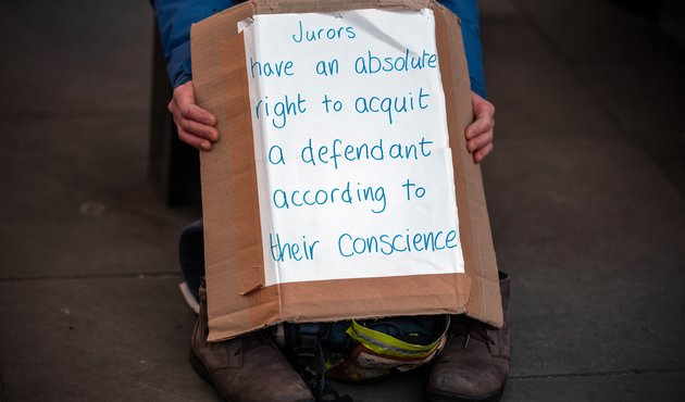 A close up photo of someone holding a handmade sign that reads: 