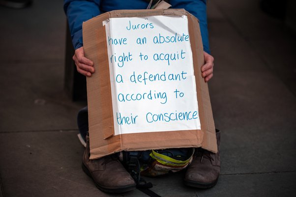 A close up photo of someone holding a handmade sign that reads: "Jurors have an absolute right to acquit a defendant according to their conscience"