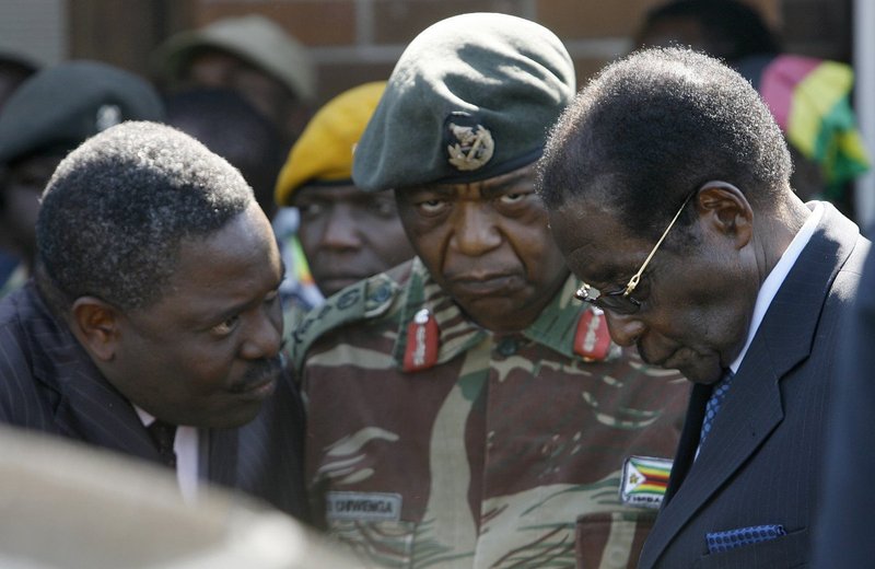 The then head of Zimbabwe Central Intelligence Organisation (CIO) Happyton Bonyongwe (L) with Constantine Chiwenga, then the commander of the Zimbabwean Army, and currently Vice President, are pictured with former President Robert Mugabe in 2008. ALEXANDE