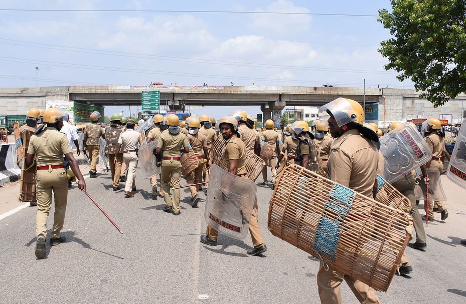 Indian police officials run towards protestors in the southern Indian city of Tuticorin on May 22, 2018, during a protest held to demand the closure of a copper factory owned by mining giant Vedanta. AFP via Getty Images