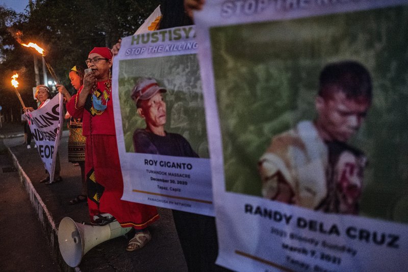 Activists hold up torches and portraits of slain Indigenous Peoples and environmental defenders during a rally on November 10, 2022 in Quezon city, Metro Manila, Philippines