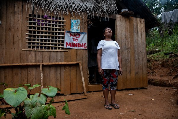 Ading Releno, anti-mining member of the Mangyan-Tagabukid indigenous community affected by the ongoing mining operations in Sibuyan Island, stands outside her house with a "No To Mining" sign in Sibuyan Island in Romblon province, central Philippines