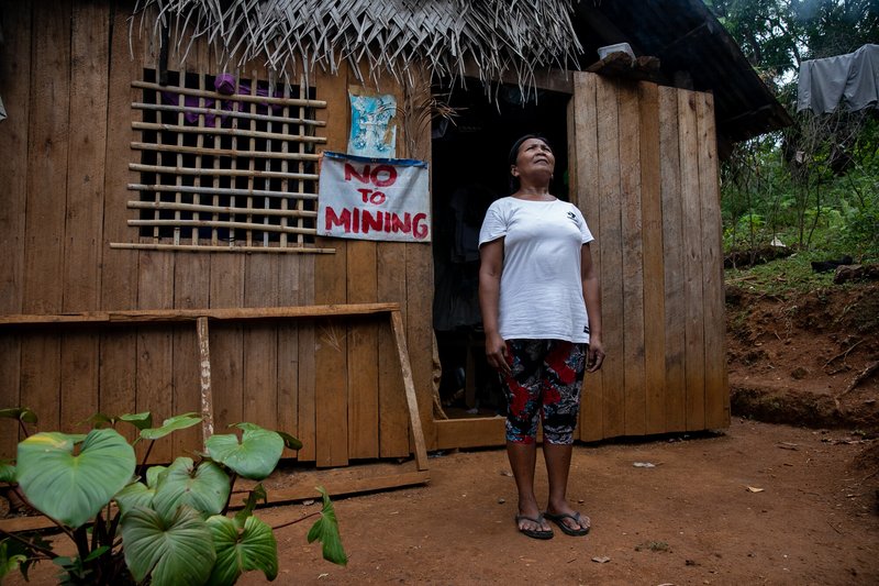 Ading Releno, anti-mining member of the Mangyan-Tagabukid indigenous community affected by the ongoing mining operations in Sibuyan Island, stands outside her house with a 