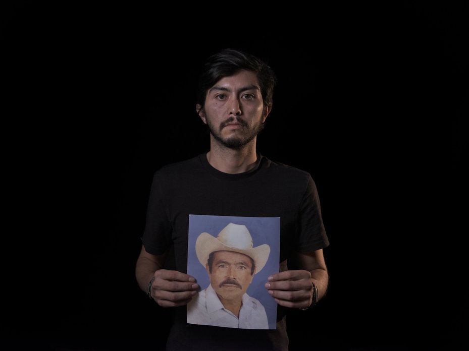 Keivan Díaz holding a picture of his grandfather, Antonio Díaz