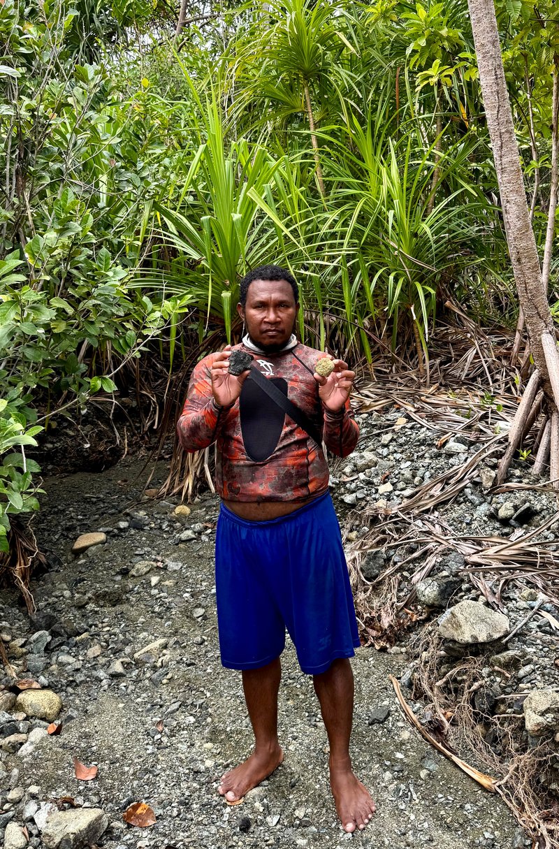 Lindert Mambrasar holding nickel on beach looking into camera