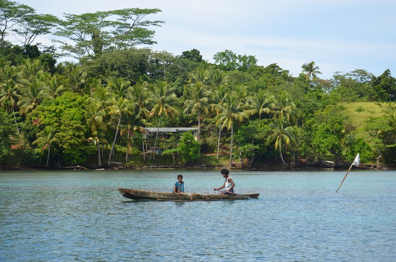 Residents of Manus Island, Papua New Guinea navigating coastal waters in an outrigger canoe