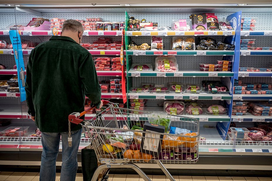 A customer shops for meat at a British supermarket.