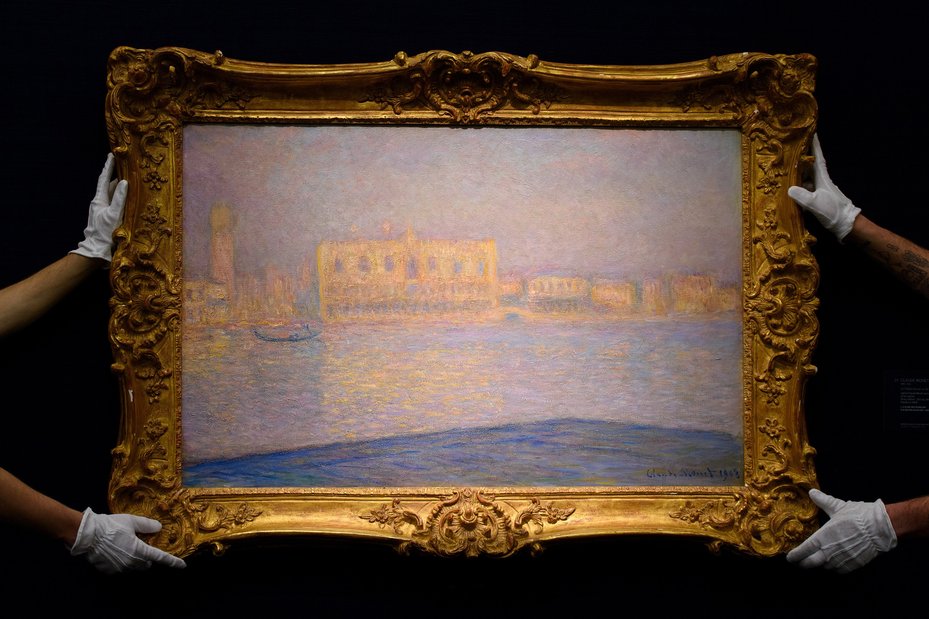 hands holding up framed Monet’s Saint-Georges Majeur