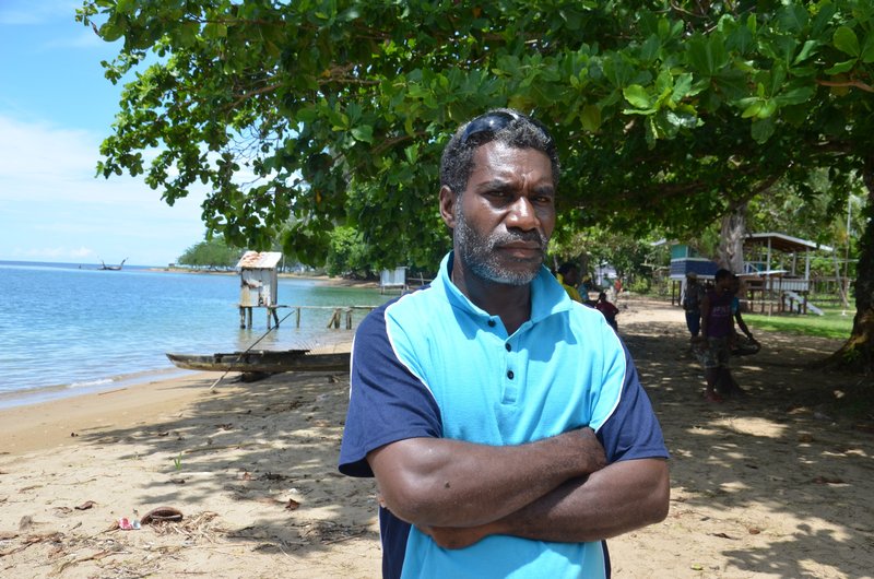 Mr Eddie Kalai, a landowner on Manus Island affected by the Maxland operations, Papua New Guinea, stands on a beach with his arms folded as he talks about deforestation affecting his home