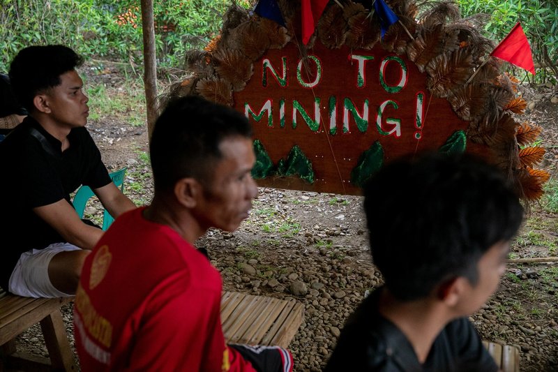 Residents sit beside a 