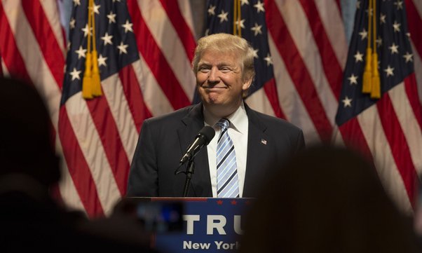 Donald Trump standing infront of the USA flags