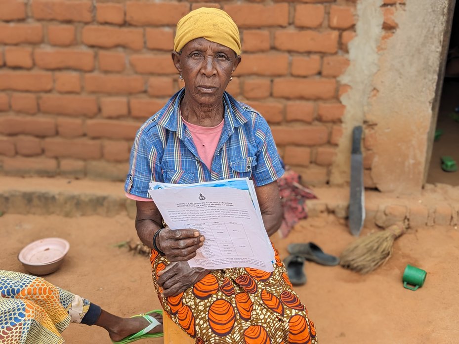 A woman holds up an eviction notice sent by the Tanzania Petroleum Development Corporation (Green Conservers)