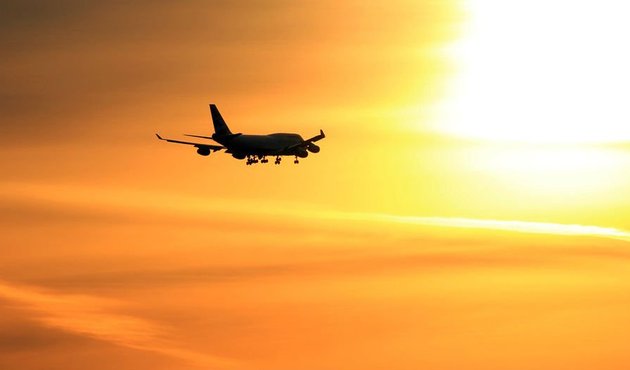 A plane taking off into sun