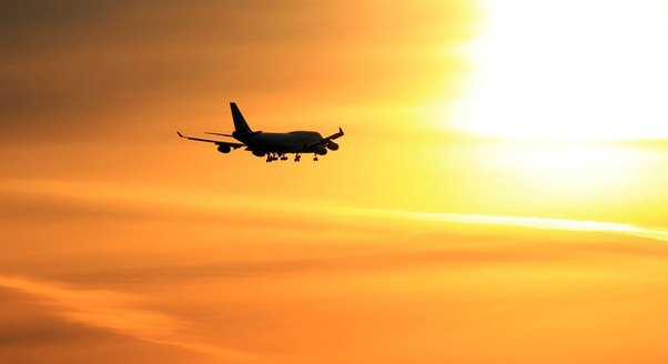 A plane taking off into sun