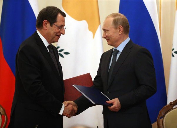 Cyprus President Nicos Anastasiades shakes hands with Valdimir Putin