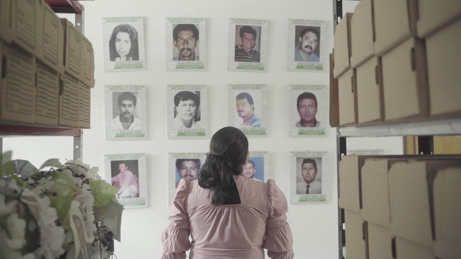 Yuli Velazquez  looks at photos of local murdered human rights defenders, Barrancabermeja, Colombia, 21 July 2022