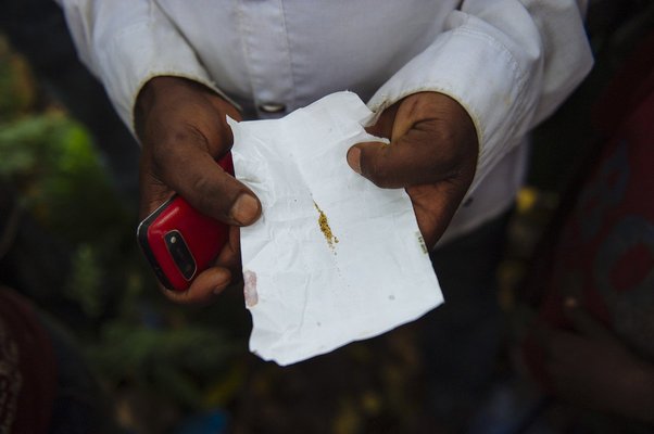 A man holds two "sticks" worth of gold dust that he panned from the Zalya river that morning in the village of Tanda Kaseti in Mwenga territory of South Kivu in the east of the Democratic Republic of the Congo on April 10, 2015.