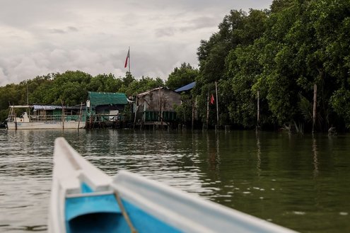 Stilt houses are seen beside mangroves along a river in Paombong town in Bulacan province, north of Manila, Philippines. August 15, 2022.