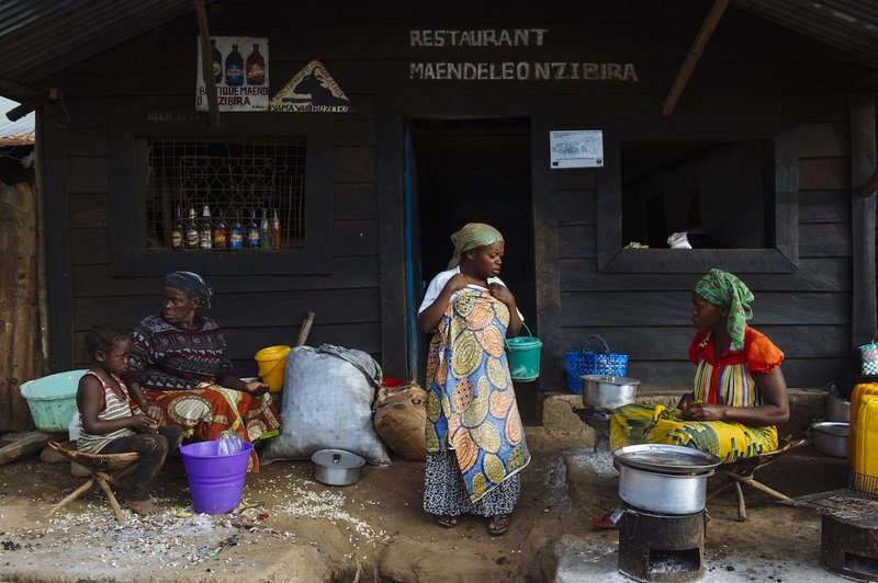 Women work outside a restaurant in the mining town of Nzibira in South Kivu province in the east of the Democratic Republic of the Congo on April 4, 2015. The small town is lined with restaurants, catering for miners.