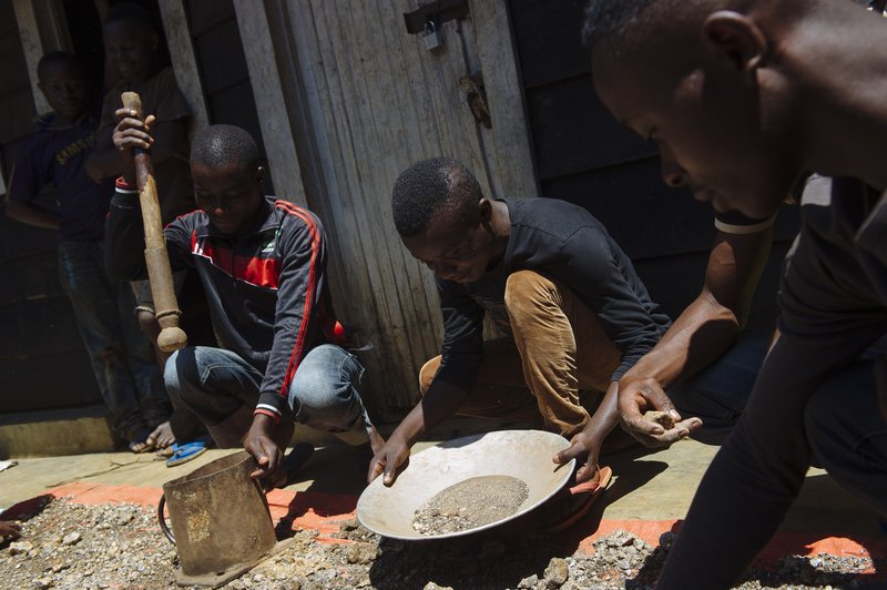 Workers filter stocks of cassiterite ore