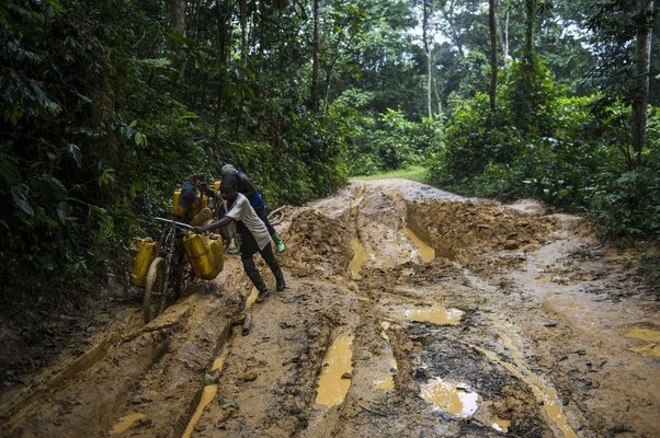 Men push bicycles laden with jerry cans along a dirt-road leading down from the gold-mining town of Lugushwa in South Kivu in the east of the Democratic Republic of the Congo on April 9, 2015.