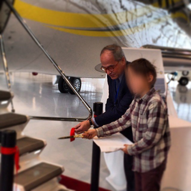 Tinkov's son, Roman, cutting a ribbon on a plane's staircase