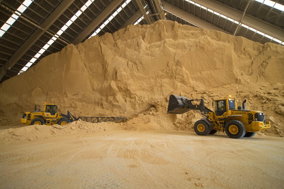 Shovel loaders handle soybean meal at a bulk storage facility