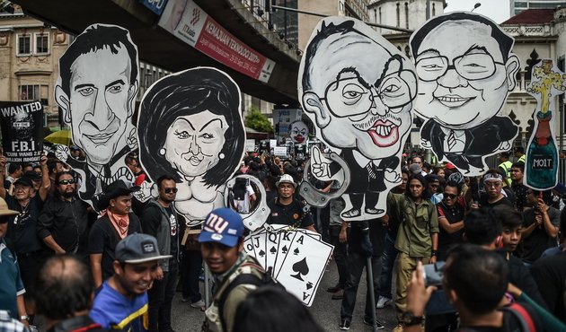 Protesters holds up clown-faced caricatures of Malaysian Prime Minister Najib Razak and his wife during a protest over the 1MDB scandal in Kuala Lumpur in August 2016