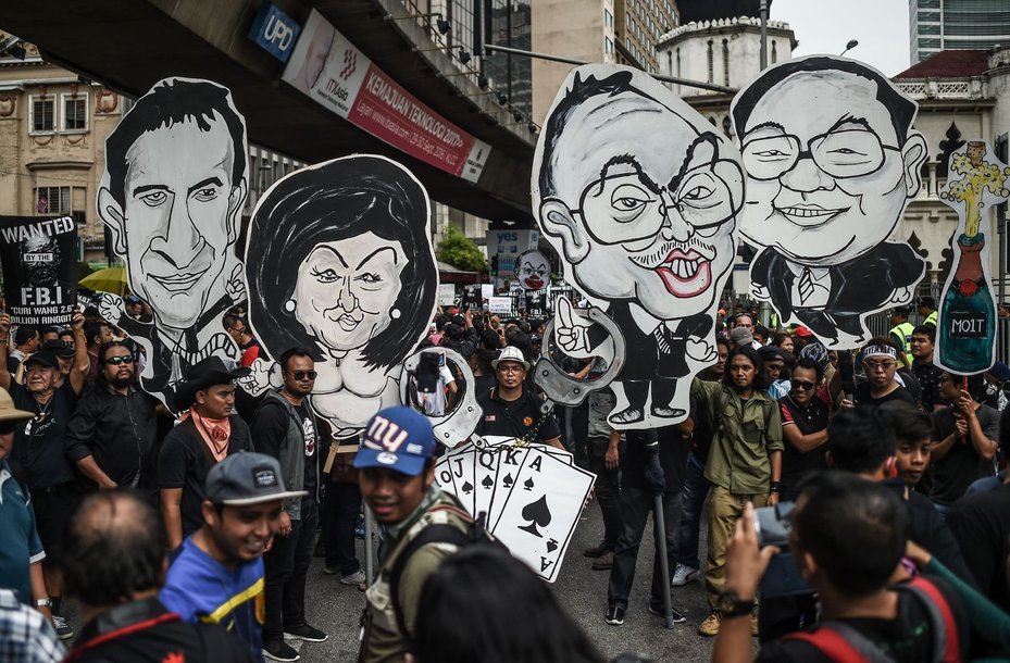 Protesters holds up clown-faced caricatures of Malaysian Prime Minister Najib Razak and his wife during a protest over the 1MDB scandal in Kuala Lumpur in August 2016