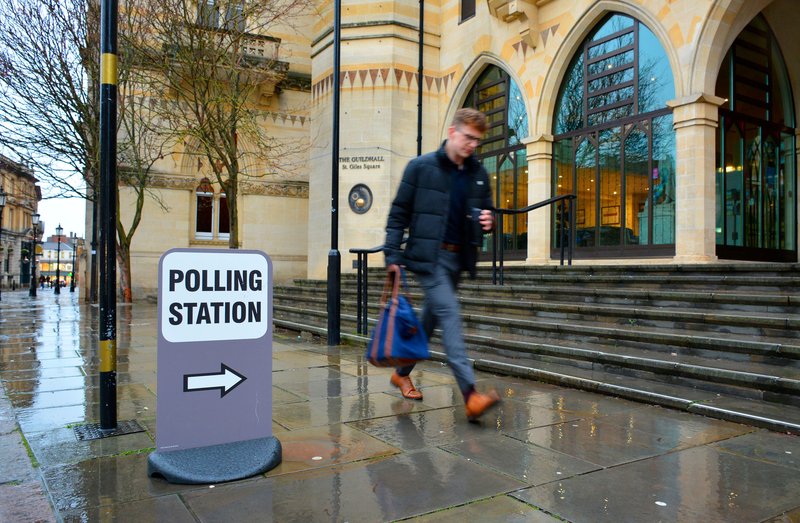 Man walking past a polling station during the UK general election at the Guilldhall, Northampton