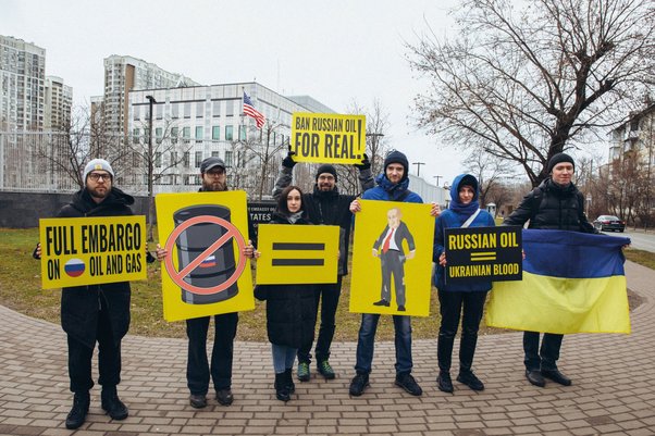 Ukrainian activists hold a banner calling for a complete ban on the trade of Russian at the US Embassy in Kyiv, February 2023