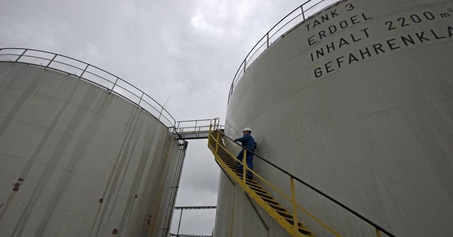 An employee from the company Wintershall Dea climbing a petroleum tank