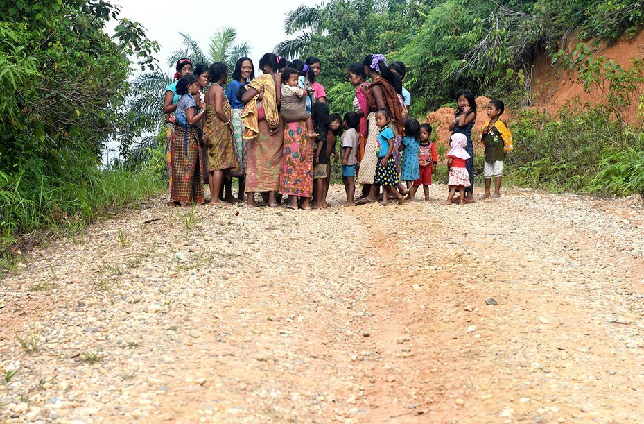 Women from the Orang Rimba tribe gathered with children near their camp in Jambi province, Indonesia