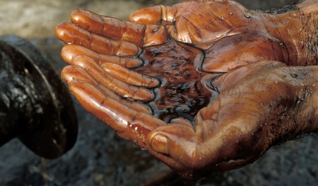 A photograph of a pair of hands, cupped, holding oil